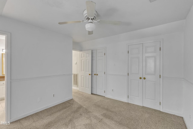 unfurnished bedroom featuring ensuite bath, multiple closets, carpet, baseboards, and visible vents