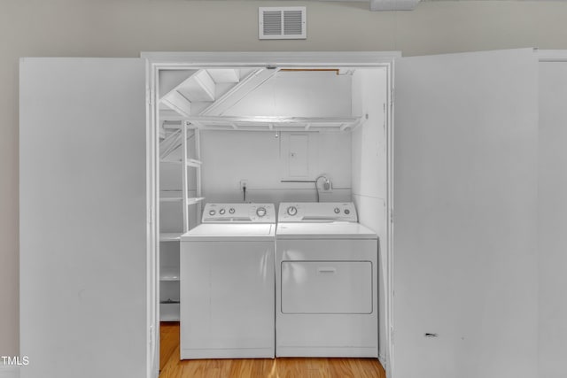 laundry room featuring separate washer and dryer, laundry area, visible vents, and light wood-type flooring
