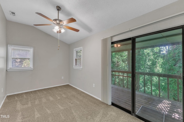 empty room featuring visible vents, carpet floors, lofted ceiling, baseboards, and ceiling fan