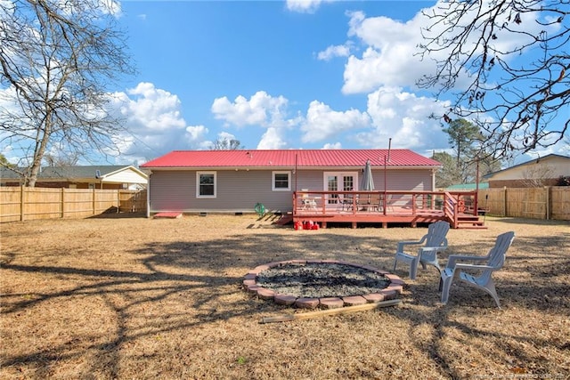 back of property featuring a wooden deck and a yard