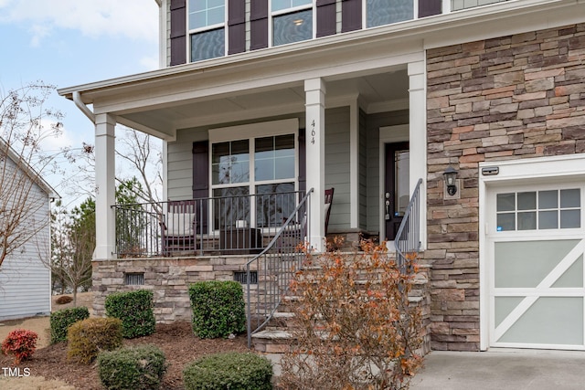 property entrance featuring a garage, stone siding, and covered porch