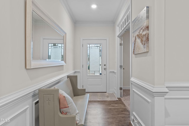 doorway with a wainscoted wall, ornamental molding, and wood finished floors