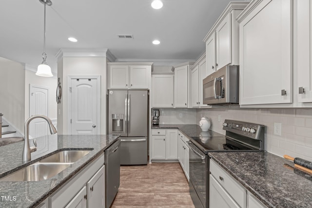 kitchen featuring a sink, visible vents, white cabinets, hanging light fixtures, and appliances with stainless steel finishes