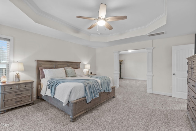 bedroom featuring a tray ceiling, decorative columns, visible vents, and crown molding