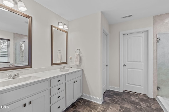 bathroom with a stall shower, baseboards, visible vents, and a sink