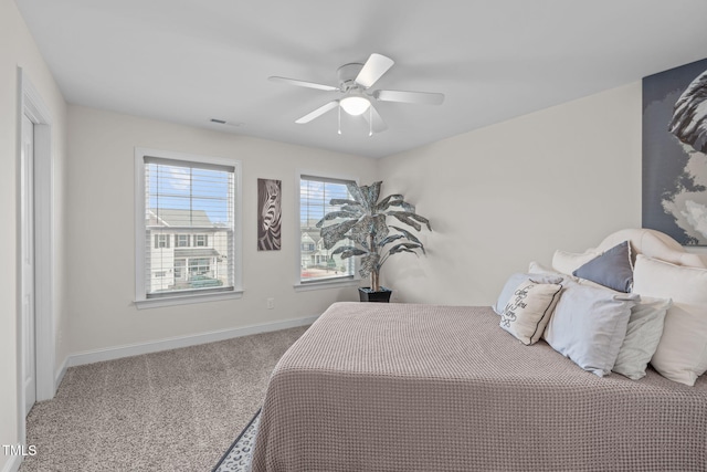 carpeted bedroom with ceiling fan and baseboards