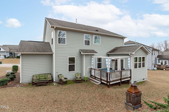 back of house with a shingled roof, a lawn, and a wooden deck