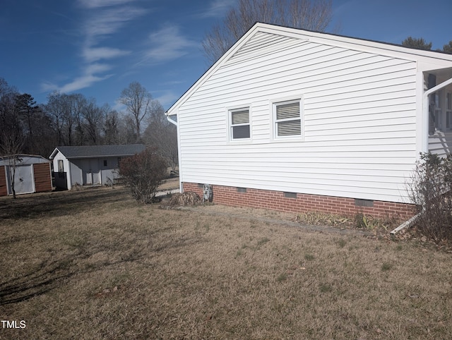 view of home's exterior with a storage unit and a lawn