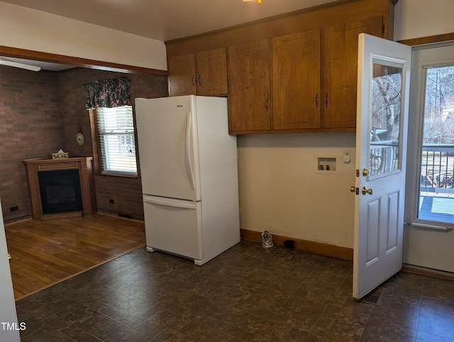 kitchen with brick wall and white refrigerator