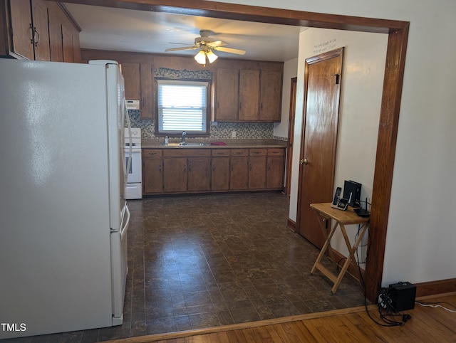 kitchen featuring ceiling fan, sink, backsplash, and white appliances