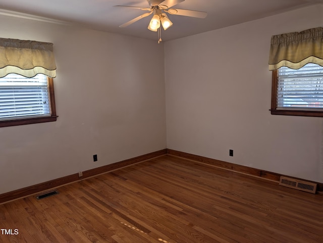 empty room with hardwood / wood-style floors and ceiling fan