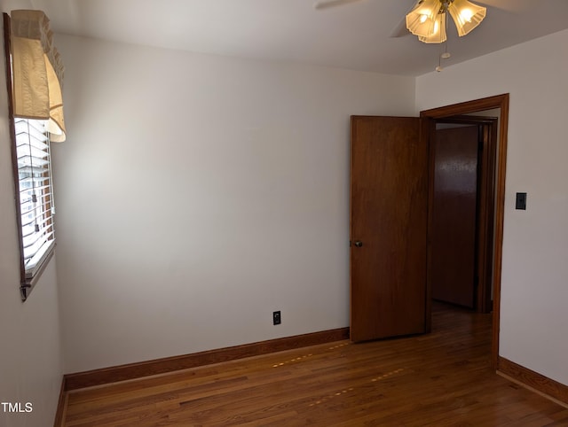 empty room with dark wood-type flooring and ceiling fan