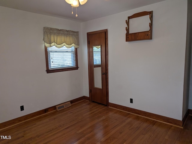 unfurnished room with dark wood-type flooring and ceiling fan