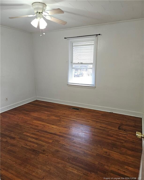 unfurnished room with dark wood-type flooring and ceiling fan