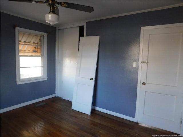 unfurnished bedroom featuring a closet, ornamental molding, and dark hardwood / wood-style floors