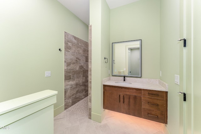 bathroom with tile patterned floors, vanity, and tiled shower