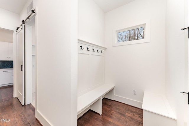 mudroom with dark hardwood / wood-style floors and a barn door