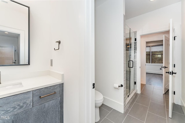 bathroom featuring vanity, tile patterned flooring, toilet, and a shower with door