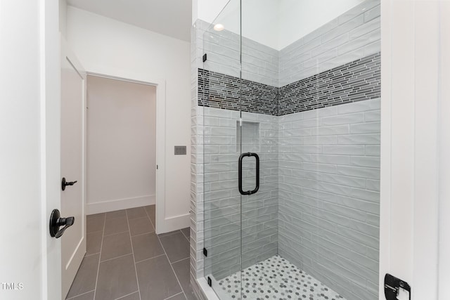 bathroom featuring a shower with shower door and tile patterned flooring