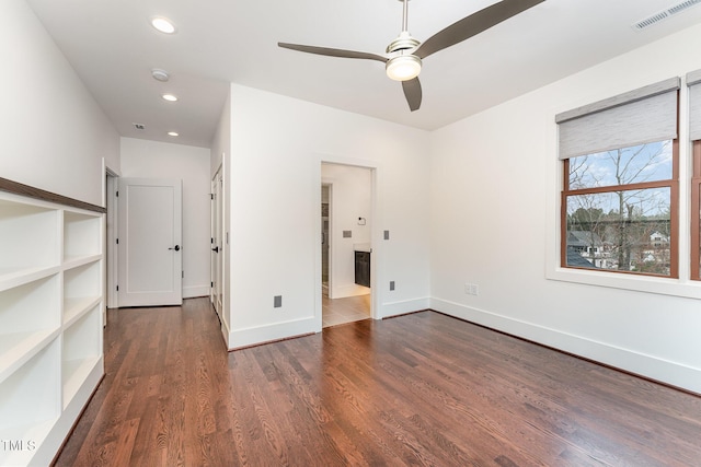 unfurnished bedroom featuring dark wood-type flooring and ensuite bath