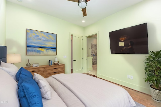 bedroom with ensuite bathroom and hardwood / wood-style flooring