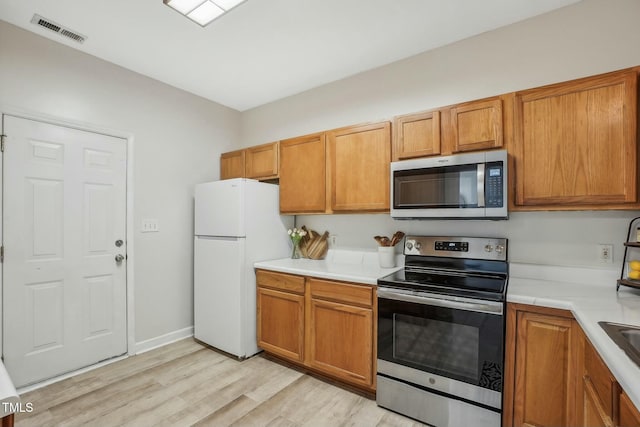 kitchen with appliances with stainless steel finishes and light wood-type flooring