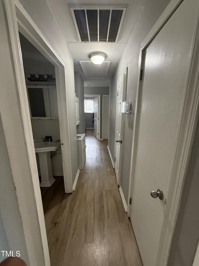 corridor with light hardwood / wood-style floors