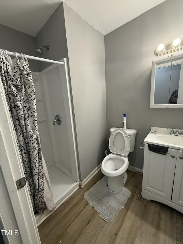 bathroom featuring walk in shower, wood-type flooring, toilet, and vanity