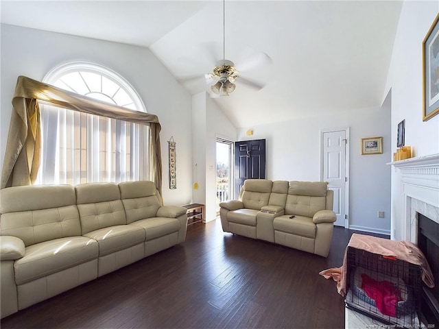 living room featuring a tiled fireplace, plenty of natural light, dark hardwood / wood-style floors, and lofted ceiling