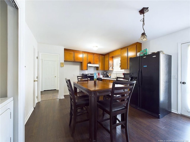 kitchen with dark wood-type flooring, black fridge, electric range, pendant lighting, and washer / clothes dryer