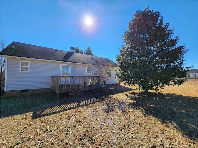 back of property with a wooden deck and a yard