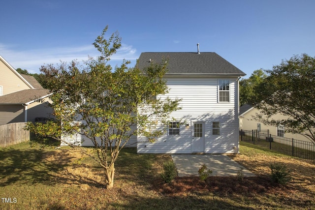 back of house featuring a patio area and a lawn