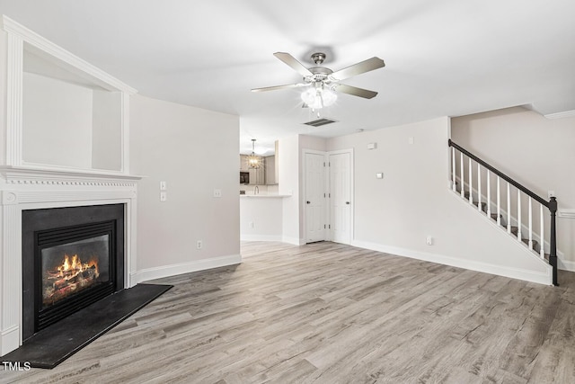 unfurnished living room with ceiling fan and light hardwood / wood-style flooring