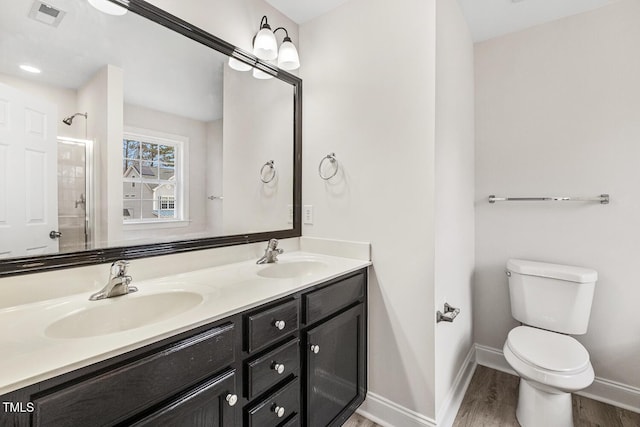 bathroom with vanity, toilet, hardwood / wood-style floors, and a shower