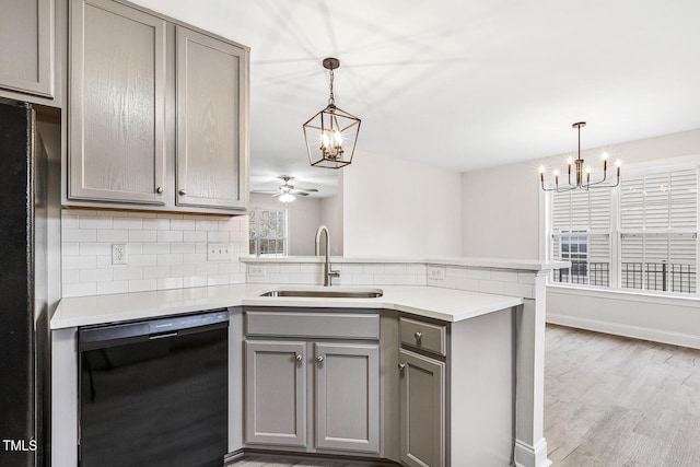 kitchen featuring pendant lighting, sink, black appliances, and kitchen peninsula