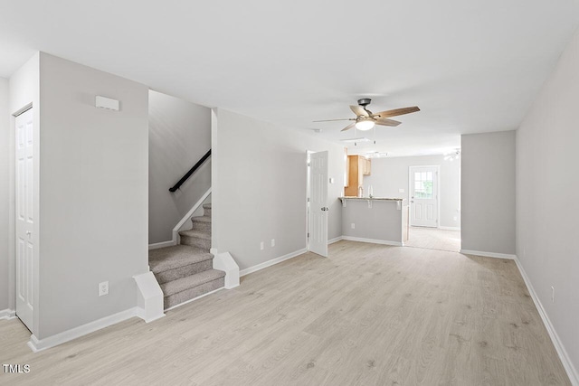 unfurnished living room with ceiling fan and light hardwood / wood-style flooring