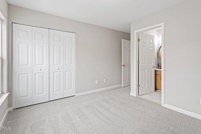 unfurnished bedroom with light colored carpet and a closet