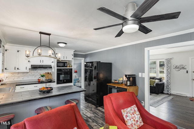 kitchen featuring pendant lighting, crown molding, black appliances, and white cabinets