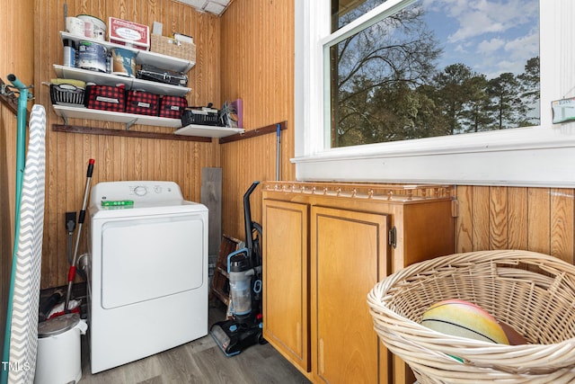 laundry area with washer / clothes dryer, hardwood / wood-style floors, and wooden walls