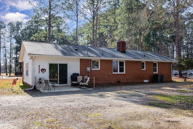 back of property with central AC and a patio