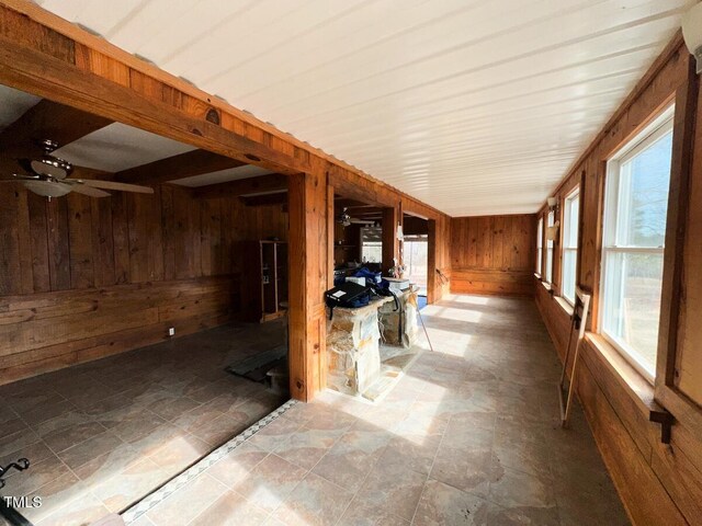 unfurnished sunroom with ceiling fan