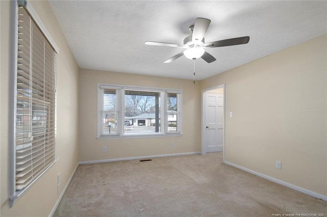 empty room with ceiling fan and light colored carpet