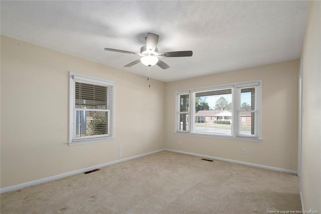 carpeted spare room featuring ceiling fan