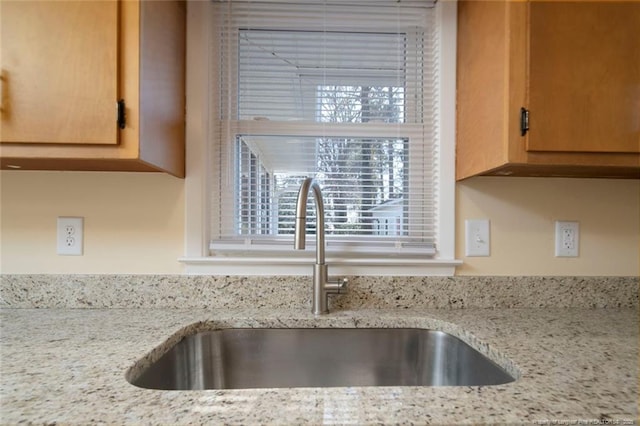 interior details with sink and light stone countertops