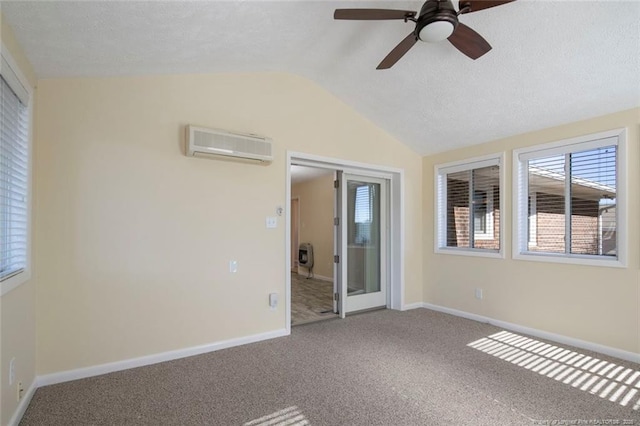 spare room with lofted ceiling, ceiling fan, a wall mounted AC, carpet, and a textured ceiling