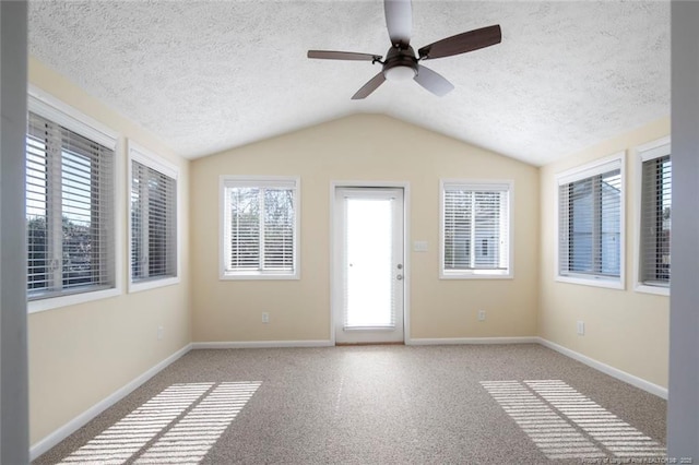 spare room with light carpet, ceiling fan, vaulted ceiling, and a textured ceiling