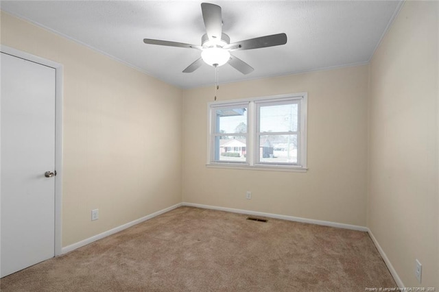 carpeted spare room with crown molding and ceiling fan