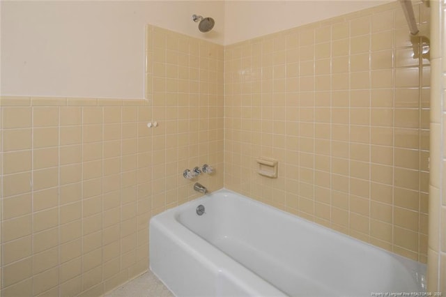 bathroom featuring tile walls and tiled shower / bath