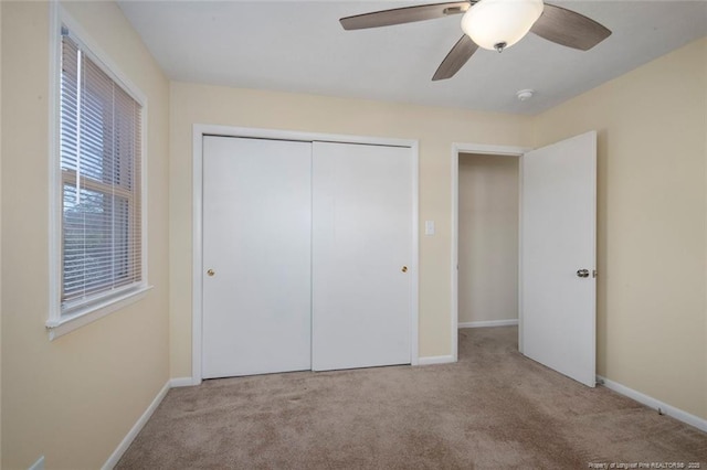 unfurnished bedroom featuring ceiling fan, a closet, and light carpet