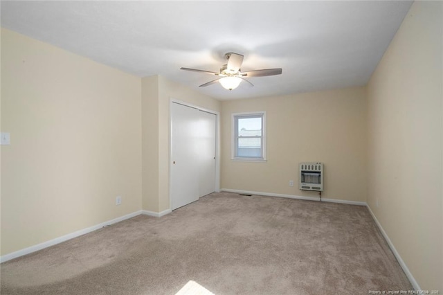 carpeted empty room with heating unit and ceiling fan